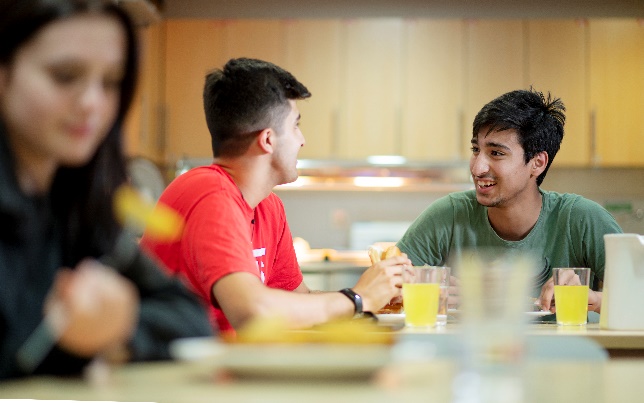 A group of people sitting at a tableDe ion automatically generated with medium confidence